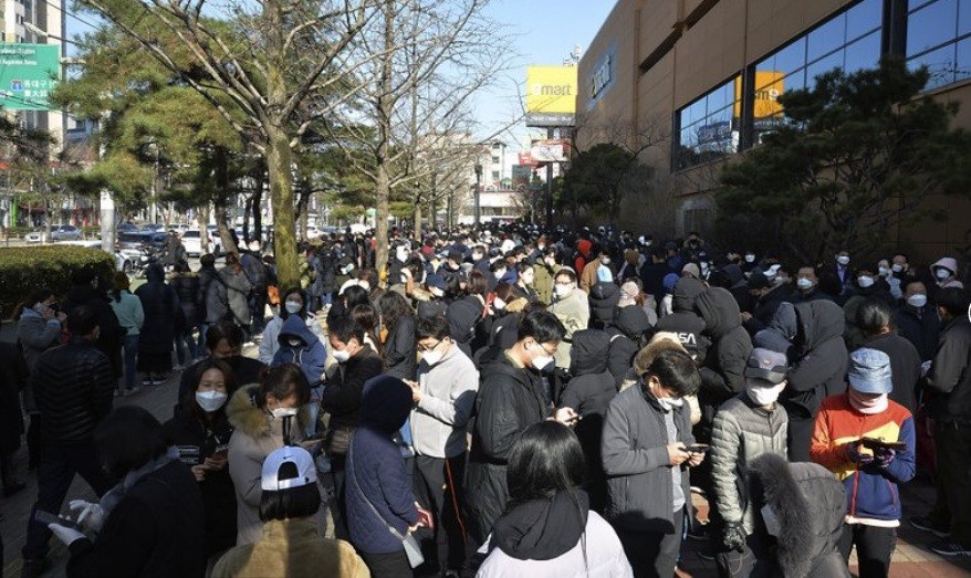 Người dân Hàn Quốc xếp hàng trước cửa hàng ở TP Daegu hôm 24/2 để chờ mua khẩu trang. Ảnh: AP