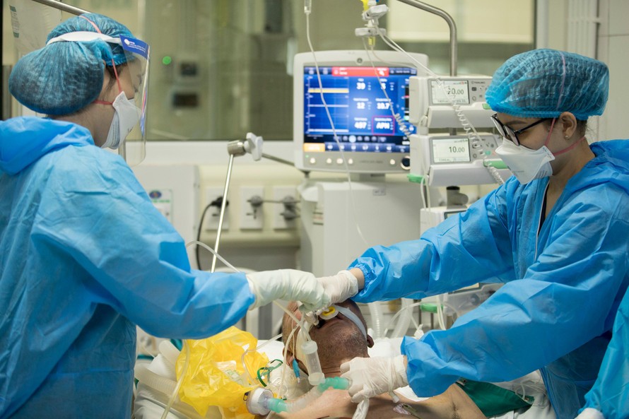 Bác sĩ Liên (bên phải) và điều dưỡng Hương rút ống thở cho bệnh nhân COVID-19 nặng. Ảnh: Thái Hà 