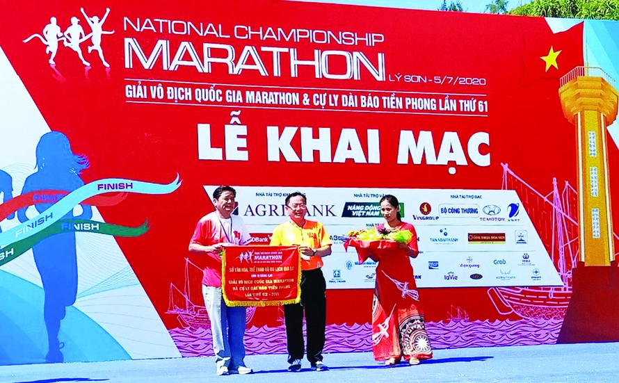 Ông Trần Ngọc Nhung - Giám đốc Sở VHTTDL Gia Lai, nhận cờ đăng cai tổ chức giải năm 2021 từ trưởng BTC Tiền Phong Marathon 2020 Lê Xuân Sơn. Ảnh: Như Ý
