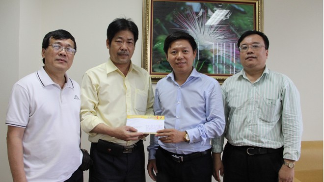Phó TBT báo Tiền Phong Trần Thanh Lâm (thứ 2 từ phải sang) nhận số tiền hỗ trợ từ đại diện Cienco 4. Ảnh: Công Khanh