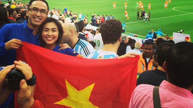 Tăng Thanh Hà và chồng hạnh phúc trên khán đài. Cặp đôi không quên mang theo lá cờ đỏ sao vàng tới sân vận động ở Sao Paulo. 