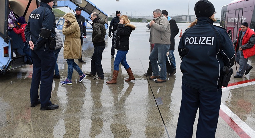 Những người xin tị nạn được hộ tống lên máy bay tại miền nam nước Đức. Ảnh: AP