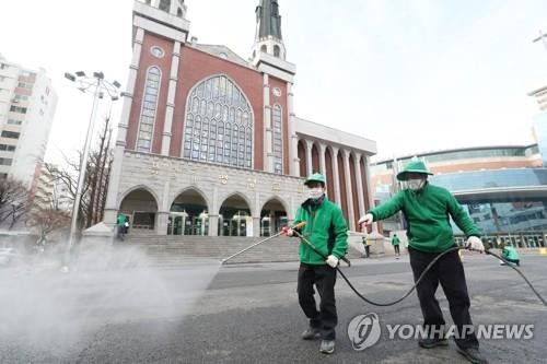 Nhân viên vệ sinh khử trùng khu vực bên ngoài một nhà thờ ở Seoul. Ảnh: Yonhap