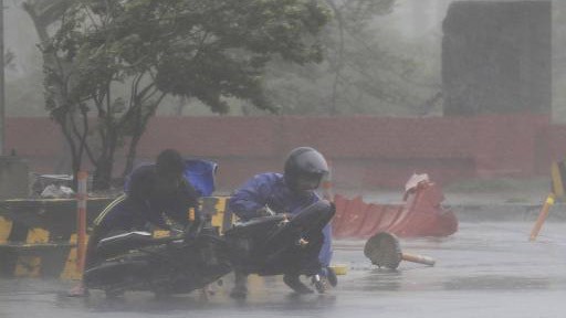 Người đi xe máy bị bão Thần Sấm quật ngã ở Manila