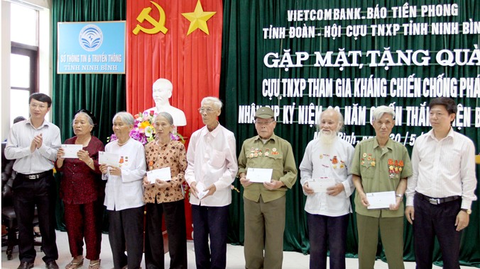 Nhà báo Trần Thanh Lâm (ngoài cùng bên phải), ông Đinh Mạnh Tuân, Phó giám đốc Ngân hàng Vietcombank chi nhánh Ninh Bình (ngoài cùng bên trái) trao quà cho cựu TNXP