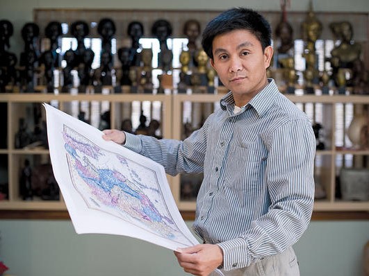 Anh Trần Đình Thắng cầm trên tay một tấm bản đồ tại nhà riêng ở West Hartford, Connecticut