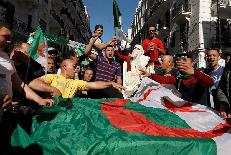 Người biểu tình Algeria mang theo cờ để phản đối tổng thống kéo dài nhiệm kỳ và trì hoãn bầu cử. (Ảnh: Reuters)