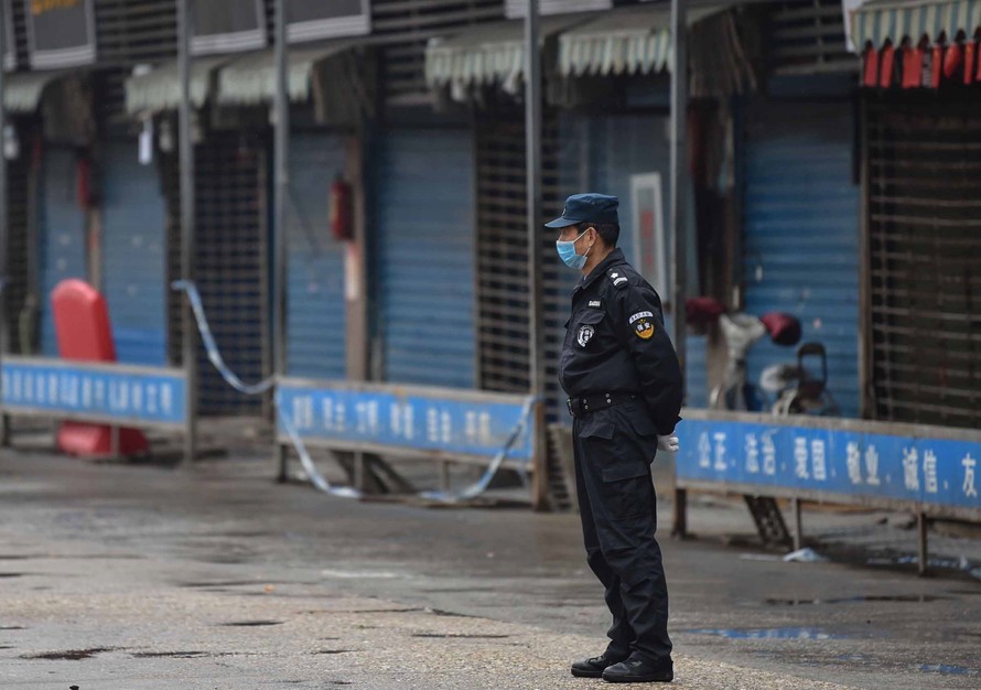 An ninh đứng canh tại khu chợ bán đồ tươi sống ở Vũ Hán, nơi được coi là địa điểm đầu tiên bùng phát đại dịch COVID-19. (Ảnh: Getty Images)