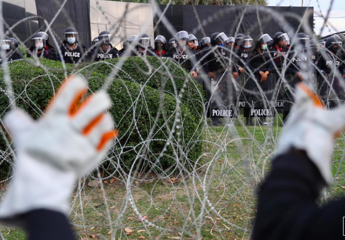 Người biểu tình cố kéo đổ hàng rào dây thép gai khi biểu tình trước Trung đoàn bộ binh số 11. (Ảnh: Reuters)