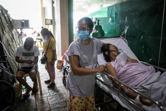 Bệnh nhân được điều trị bên ngoài một bệnh viện ở TP Quezon vì phòng bệnh đã kín. (Ảnh: Reuters)