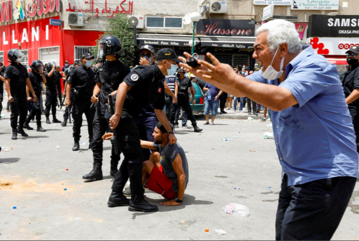 Một người đàn ông phản ứng khi cảnh sát bắt một người biểu tình ở Tunis ngày 25/7. (Ảnh: Reuters)