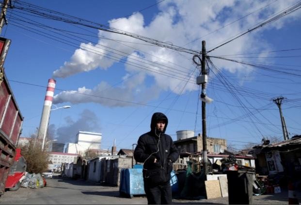 Một người đàn ông đang đi gần nhà máy điện than ở Cáp Nhĩ Tân, tỉnh Hắc Long Giang, Trung Quốc. (Ảnh: Reuters)