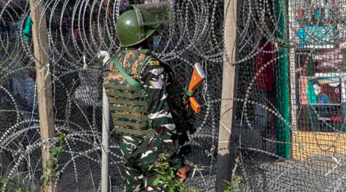 Một lính Ấn Độ đứng gác gần hàng rào dây thép gai ở Srinagar ngày 12/10. (Ảnh: AP)