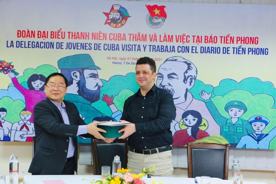 Nhà báo Lê Xuân Sơn - Tổng biên tập báo Tiền Phong, tặng quà lưu niệm cho đoàn thanh niên Cuba. (Ảnh: Trọng Tài)