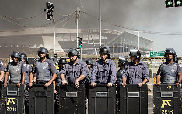Cảnh sát Brazil ngăn chặn người biểu tình bên ngoài sân vận động World Cup tại Sao Paulo Ảnh: Ben Tavener - breakingnews.com)