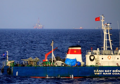 Tàu của cảnh sát biển Việt Nam thực hiện nhiệm vụ tại khu vực quần đảo Hoàng Sa. Phía xa là giàn khoan 981 mà Trung Quốc hạ đặt trái phép. Ảnh: Nguyễn Đông