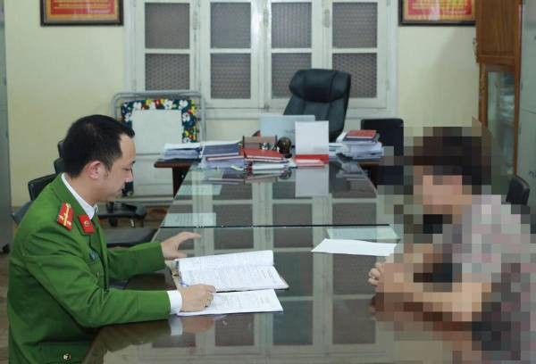 Thượng úy Nguyễn Danh Đạt lấy lời khai nghi phạm.