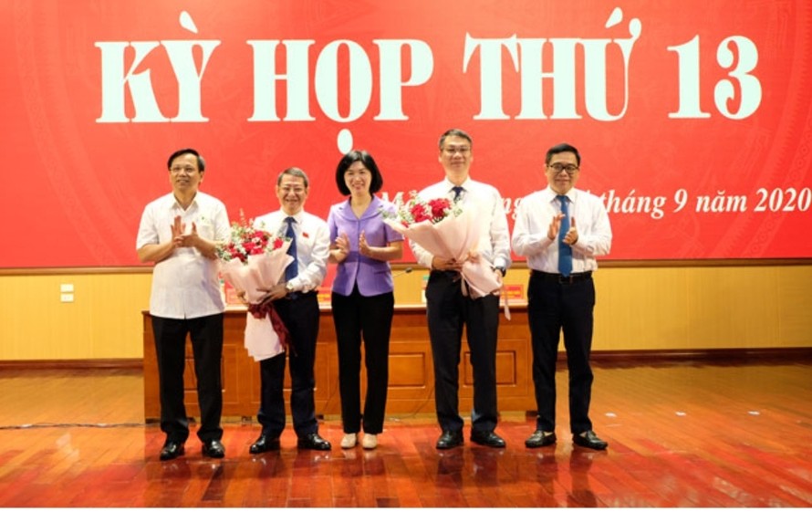 Phó Chủ tịch HĐND thành phố Phùng Thị Hồng Hà tặng hoa chúc mừng các đồng chí lãnh đạo huyện Mê Linh. Ảnh: Hoàng Sơn.