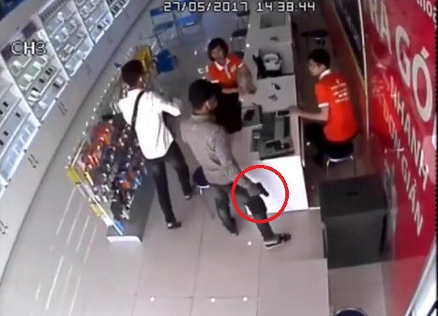 Hình ảnh từ camera cho thấy nam thanh niên cầm vật hình súng xông vào cửa hàng điện thoại. Ảnh cắt từ clip