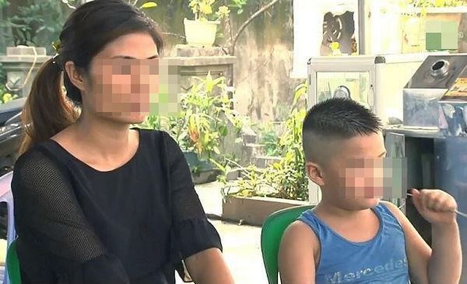 Bé Đoàn Nhật M. bên chị Vũ Thị Hương, người không phải mẹ đẻ nuôi dưỡng con suốt 6 năm qua. Ảnh: Phạm Nhung.