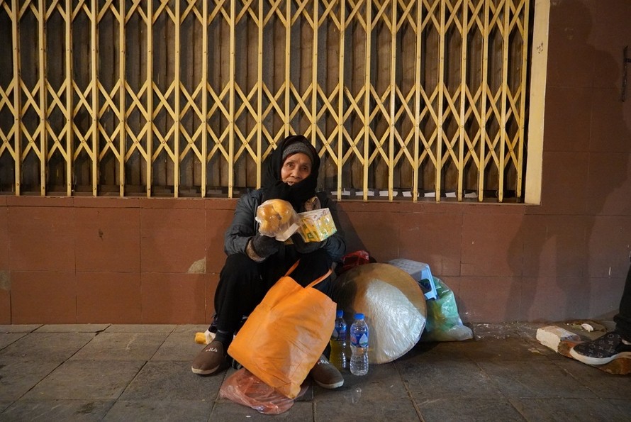 Một cụ bà không nhà cửa phải co ro trong đêm đông Hà Nội.