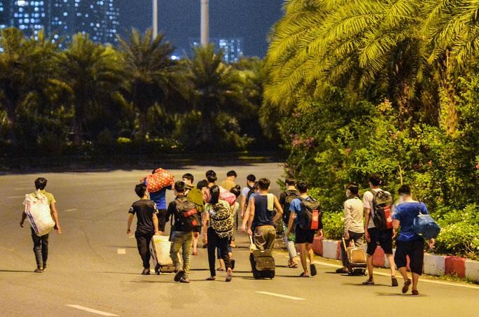 Lao động tự do đi bộ ở Đại lộ Thăng Long về quê. Ảnh: Người lao động