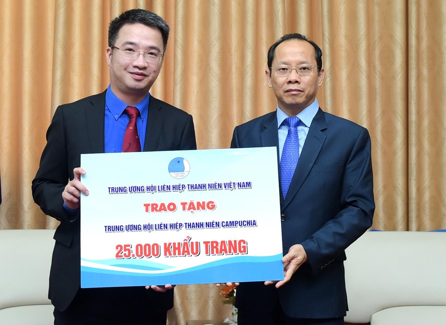 Anh Nguyễn Tường Lâm trao biển tặng 25.000 khẩu trang tới ông Chay Navuth. Ảnh: Xuân Tùng