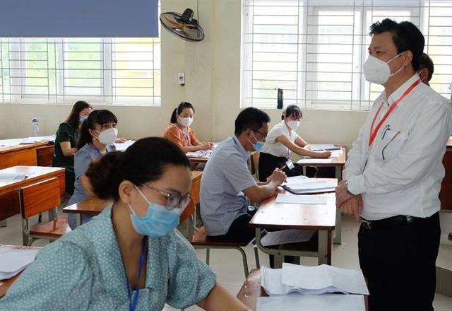 Thứ trưởng Bộ GD - ĐT Nguyễn Hữu Độ trao đổi với giáo viên tham gia chấm bài thi Ngữ văn tại tỉnh Yên Bái.