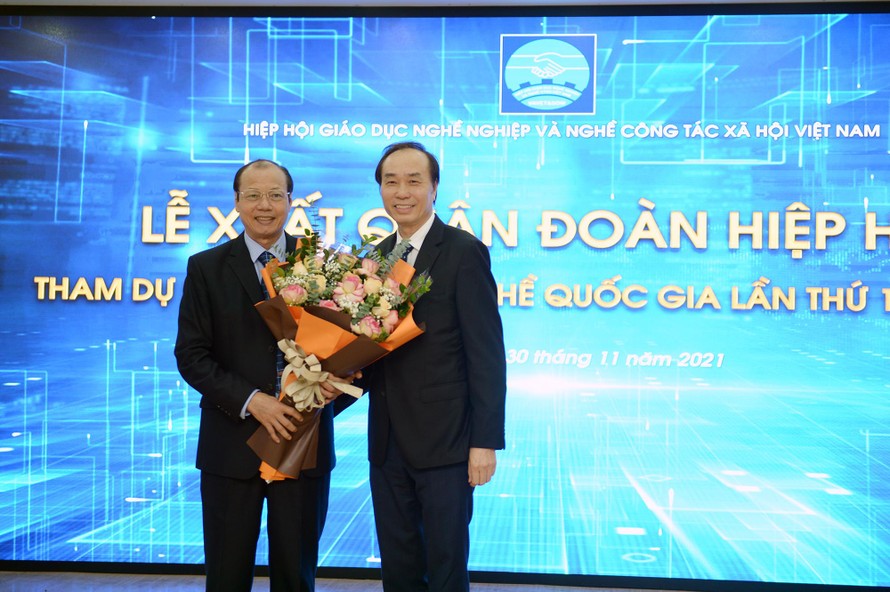 Chủ tịch Hiệp hội GDNN và nghề CTXH Việt Nam Dương Đức Lân (bìa phải) tặng hoa cho đại diện Đoàn Hiệp hội tham dự Kỳ thi Kỹ năng nghề quốc gia lần thứ 12. 
