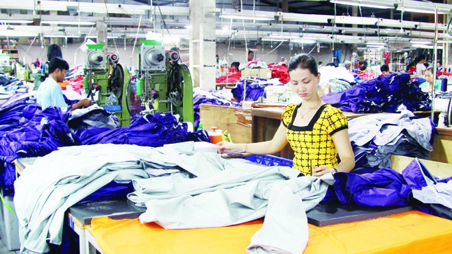  Công nhân một công ty có vốn đầu tư của Đài Loan bắt tay vào sản xuất sau những ngày tạm nghỉ vì gây rối. ảnh: S.N