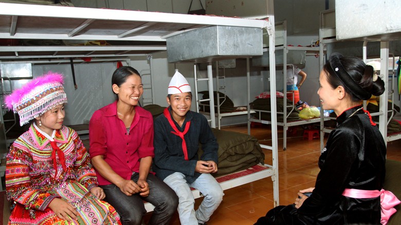 Niềm vui về nhà bán trú mới trong câu chuyện của chị Lý Thị Trài (thứ hai từ trái sang) với giáo viên chủ nhiệm của hai con. ảnh: Xuân Tùng