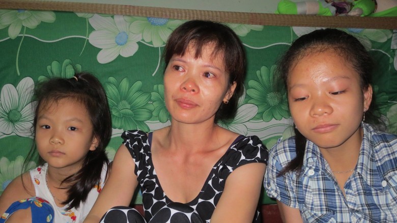  Chị Nguyễn Thị Mão cùng hai con gái xúc động kể chuyện về bố đi làm nhiệm vụ. Ảnh: Tuấn Cường
