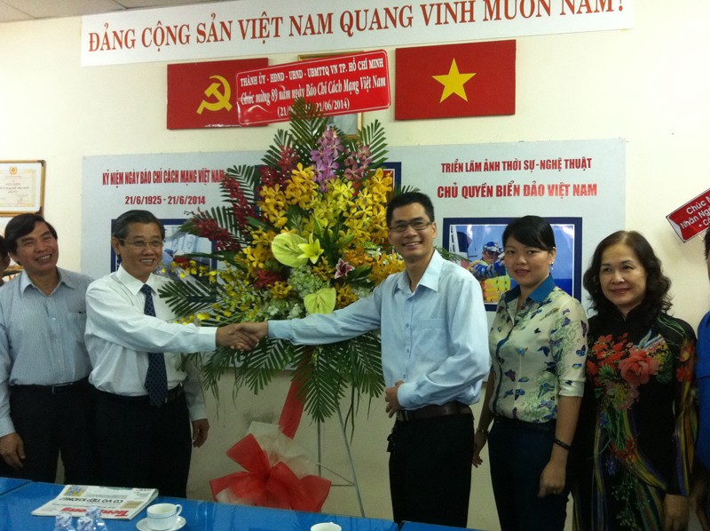 Ông Hứa Ngọc Thuận, Ủy viên Ban Thường vụ Thành ủy, Phó chủ tịch UBND TPHCM tặng hoa cho đại diện báo Tiền Phong.