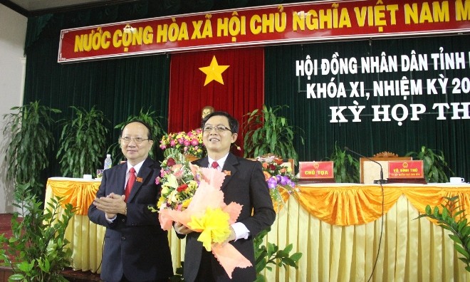 Ông Hồ Quốc Dũng (bên phải, cầm hoa) được bầu làm Chủ tịch UBND tỉnh Bình Định 