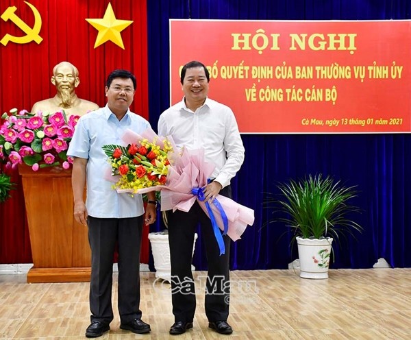 Bí thư Tỉnh uỷ Cà Mau Nguyễn Tiến Hải trao hoa, chụp ảnh lưu niệm với ông Thân Đức Hưởng (bên phải) tại buổi Lễ trao Quyết định nghỉ công tác, ngày13/1/2021. Ảnh: Báo Cà Mau
