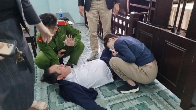 Ông Võ Văn Cường - Giám đốc Công ty TNHH MTV Land Hà Hải (áo trắng) nằm vật xuống sàn sau khi uống thuốc diệt côn trùng để tự tử tại tòa