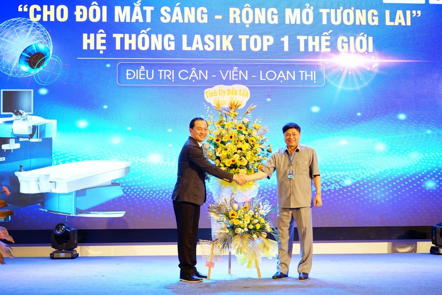 Phó bí thư Thường trực Tỉnh ủy Đắk Lắk Phạm Minh Tấn (bên phải) tặng hoa chúc mừng Bệnh viện mắt Tây Nguyên