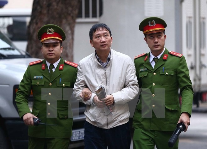 Cảnh sát dẫn giải bị cáo Trịnh Xuân Thanh, nguyên Chủ tịch Hội đồng quản trị, Tổng giám đốc Tổng Công ty Cổ phần Xây lắp dầu khí Việt Nam - PVC đến tòa. (Ảnh: Doãn Tấn/TTXVN)