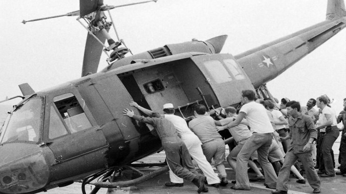 Thủy thủ tàu khu trục Mỹ USS Kirk đẩy các máy bay trực thăng xuống biển để lấy chỗ cho các trực thăng chở người di tản khác đáp xuống tháng 4/1975. Ảnh: Corbis Photo.