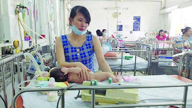 Chị Trang bên con gái 3 tháng tuổi bị biến chứng hô hấp viêm phổi nặng tại Khoa Hô hấp Bệnh viện Nhi đồng 1 TPHCM. Ảnh: Q.N.