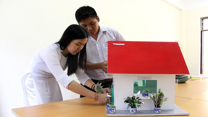 Quánh Đức Huy và Trần Mỹ Duyên với mô hình ngôi nhà giảm thiểu ô nhiễm môi trường cho khu dân cư lân cận bãi rác Khánh Sơn. Ảnh: Đào Phan.