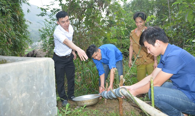 Thầy giáo Nguyễn Anh Đức cùng các học trò đang lắp đặt sản phẩm lọc nước khe núi tại nhà anh Phượng Ton Mậy ở huyện Văn Yên, Yên Bái.