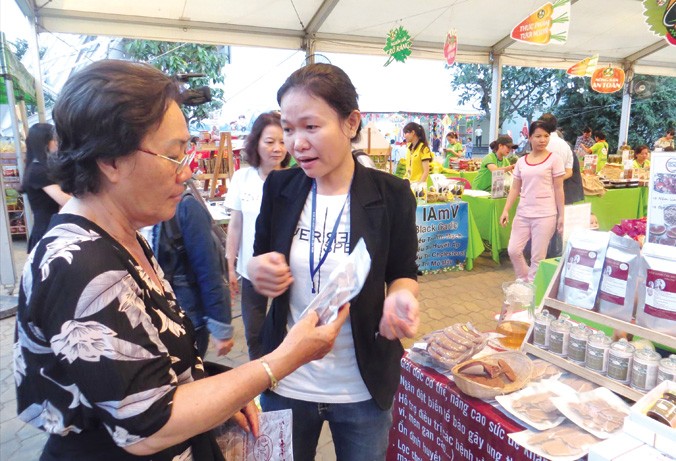 Nguyễn Thị Hiếu giới thiệu sản phẩm với khách hàng tại hội chợ Hàng Việt Nam chất lượng cao 2018. Ảnh: U.P.