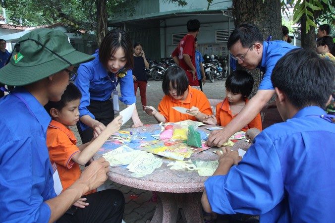 Đại biểu Thu Phương (thứ 3 từ trái qua) hướng dẫn các bạn nhỏ làm tranh cát. Ảnh: Ngô Tùng.
