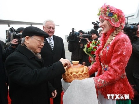 Thiếu nữ Belarus mời Tổng Bí thư Nguyễn Phú Trọng bánh mỳ và muối theo phong tục đón khách truyền thống. (Ảnh: Trí Dũng/TTXVN) 