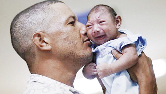 Ông bố Geovane Silva đang bế con trai Gustavo Henrique bị bệnh đầu nhỏ tại một bệnh viện ở Brazil. Ảnh: PRI