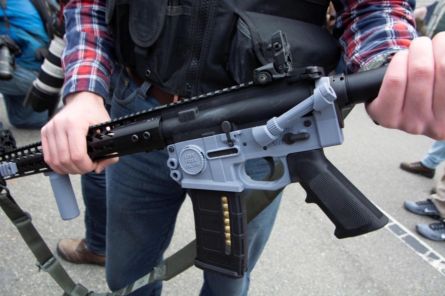 Một người đem khẩu "súng ma" được làm bằng các bộ phận in 3D tham gia biểu tình (Ảnh: Reuters)