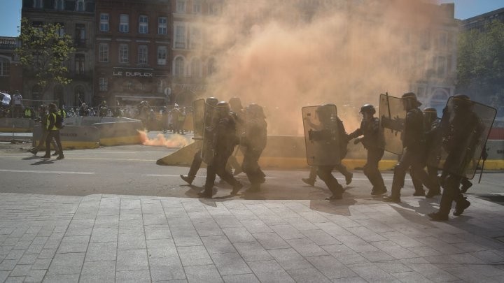 Cảnh sát chống biểu tình di chuyển giữa khói mù trong cuộc biểu tình lần thứ 22 liên tiếp vào ngày thứ bảy của phong trào 'Áo vàng'