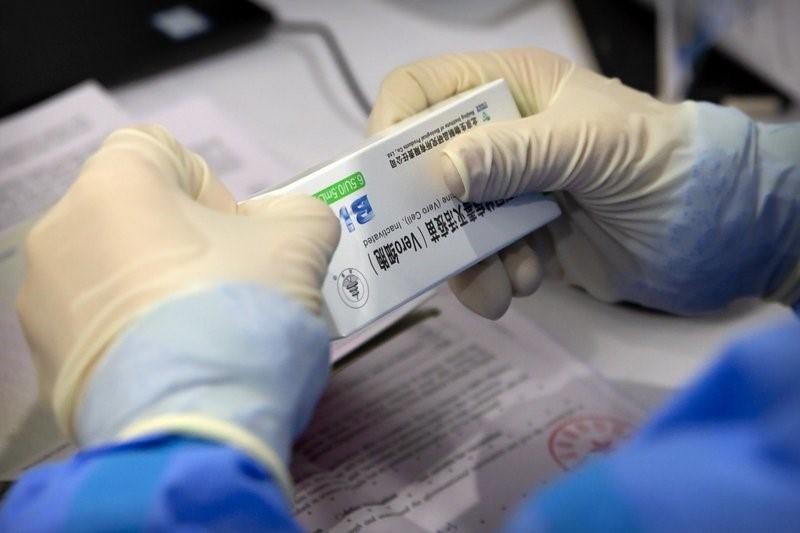 Một nhân viên y tế mở hộp vắc-xin do một công ty con của Sinopharm sản xuất trong buổi tiêm chủng COVID-19 cho các phóng viên nước ngoài thường trú ở Bắc Kinh ngày 23/3. Ảnh: AP 