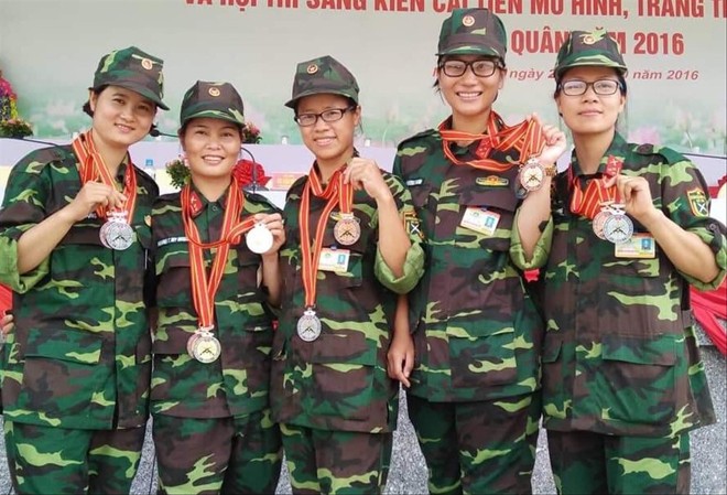 Thượng úy Đặng Thị Thùy Hương (giữa) cùng đồng đội nhận Huy chương Bạc và Đồng tại Hội thao bắn súng quân dụng toàn quân. Ảnh: NVCC